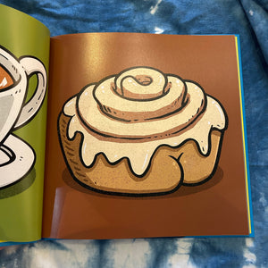 Illustration of a cinnamon roll with a butt on a page from a book called Butts on Things.