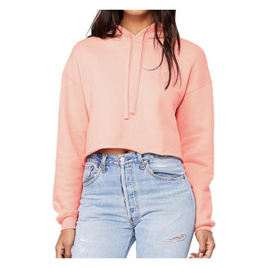 Person wearing an apricot cropped hoodie and light blue jeans on a white background.