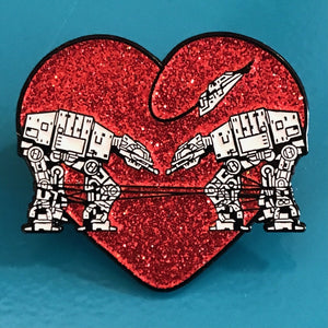 Heart shaped enamel pin called Love AT-AT First Sight with a red glitter background. Shown on a square paper background with black and white hearts.