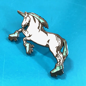An enamel pin of a unicorn standing on hind legs and wearing roller skates.