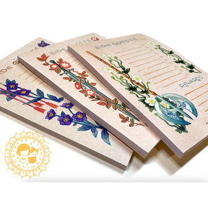 Three decorative notebooks with floral and arrow designs on a white background