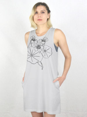 A woman modeling a sleeveless french gray shift dress with a black line art graphic of nasturtiums and leaves on the front, set against a plain white studio background.