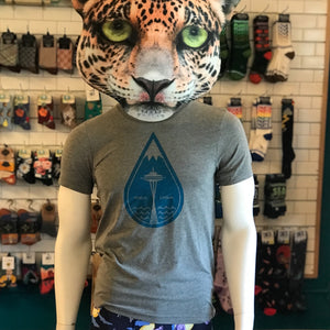 A mannequin with a cheetah mask is wearing a shirt with a big raindrop in the middle. The top of the raindrop looks like a mountain cap and there is a Space Needle in the middle.