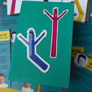 Two colorful air dancer stickers on a green card with a collage of smaller images in the background.