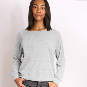 Woman wearing a gray sweater against a plain background.