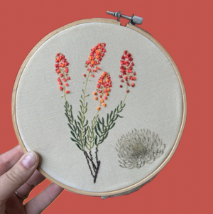 Embroidery hoop with floral design on a red background