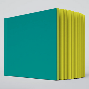 A close up photo of the Lemon Shock ugly book sketchbook. The cover is green and the pages are bright yellow colored.