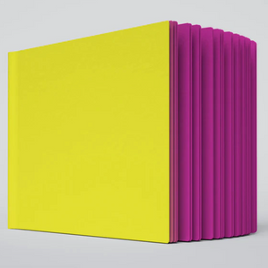A close up photo of the Razzle Dazzle ugly book sketchbook. The cover is bright yellow and the pages are hot pink colored.
