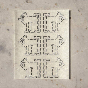 Visible mending guide sticker with a repeating pattern of six cats licking their paws.