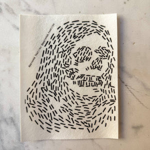Visible mending pattern sticker of a hooded skeleton face