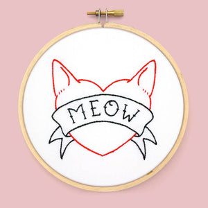 Embroidery hoop with a cat-themed design and 'MEOW' text on a pink background