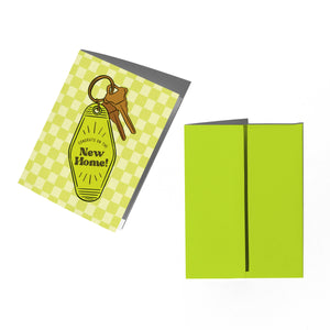 Green greeting card with a key and 'New Home' tag, and a matching green envelope on a white background.