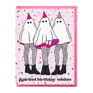 A greeting card with a light pink background speckled with small purple dots. The front features three cartoon ghosts wearing party hats, fishnet stockings, and black boots, with the text 'Spirited birthday wishes' at the bottom.