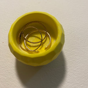 Yellow dish with gold rings on a light gray background.