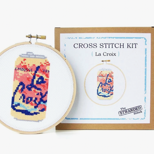 Cross stitch kit with La Croix design in an embroidery hoop and packaging on a white background