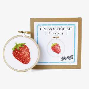 Cross stitch kit with strawberry design and box with 'The Stranded Stitch' branding on a white background