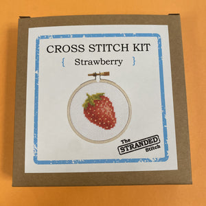 Cross stitch kit with strawberry design and box with 'The Stranded Stitch' branding on a white background