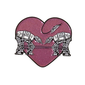 Heart shaped enamel pin called Love AT-AT First Sight with a pink glitter background.