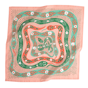 A pink bandana with a design of snakes in various shades of green and orange with floral patterns on them.