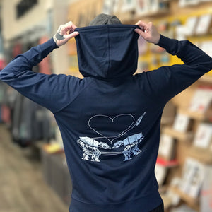 Person wearing a navy blue hoodie with the Love AT-AT First Sight design on the back in an indoor setting.