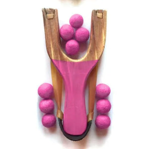 Pink slingshot with pink balls on a white background