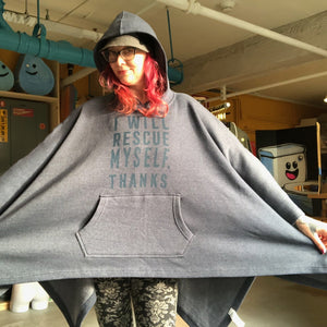 Person wearing a large navy blue hooded poncho with a kangaroo pocket.