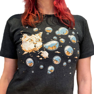 Person wearing a blue t-shirt with cartoon cat designs. There is a large cloud in the sky that looks like a giant cat head. The cat head is blowing bubbles that have tiny kitties inside.