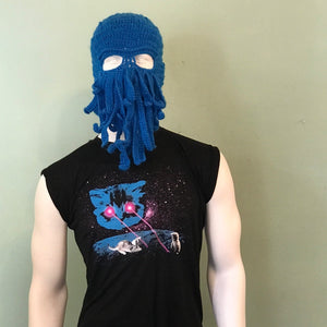 Person wearing a blue knitted balaclava and black sleeveless shirt with Meta Laser Cat graphic design against a plain background.