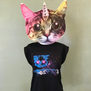 A mannequin wearing a unicorn-cat-head mask is displaying a rolled cuff muscle tee with our Meta Laser Cat design. A blue cat head is floating in space and shooting hot pink lasers out of his eyes. Kittens are playing in the lasers.