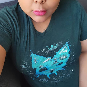 Person wearing a shirt with an island that is in the shape of a cat.