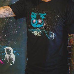 Two people wearing black t-shirts with a graphic design of a cat and laser beams, standing in front of a large screen displaying the same design.