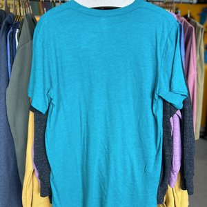 Teal t-shirt on a hanger with other colorful shirts in the background