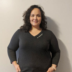 Woman wearing a dark gray shirt with text that says "No, thank you" against a plain background