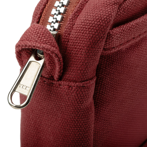 Close-up of a maroon pouch with a zipper and 'YKK' brand logo.