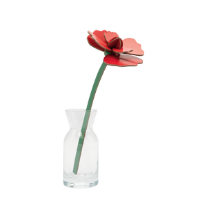 Red cardboard flower in a small glass vase.
