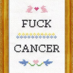 Cross-stitched design with 'F**K CANCER' text and decorative elements in a gold frame.