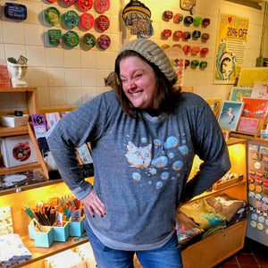 Woman in a store with shelves and products in the background.