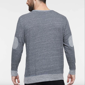 Blue long-sleeve shirt worn by a person on a white background.