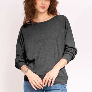 Woman wearing a dark gray long-sleeve top against a plain background.