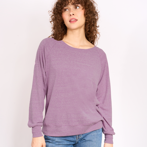 Woman wearing a purple sweater against a plain background.