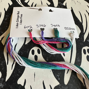 Colorful embroidery floss on a card with ghost patterns in the background