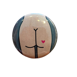 Round button with a stylized illustration of a butt with a red heart tattoo.