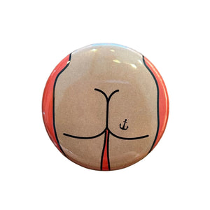 Round magnet with a cartoon butt illustration against a white background.