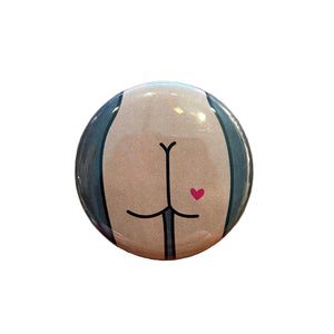 Round magnet with a cartoon butt illustration against a white background.