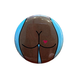 Round magnet with a cartoon illustration of a butt against a white background
