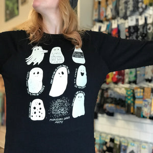 Person wearing a black sweatshirt with white ghost illustrations in a store setting.