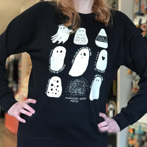A person is standing with their hands on their hips. They are wearing our A Ghost Story design on a black sweatshirt. The background of a retail store is blurry in the background.