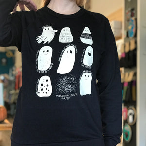 Person wearing a black sweatshirt with white ghost illustrations in a store setting.