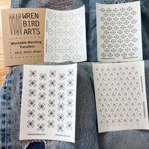 Four variations of washable mending transfers from Wren Bird Arts on top of denim fabric.