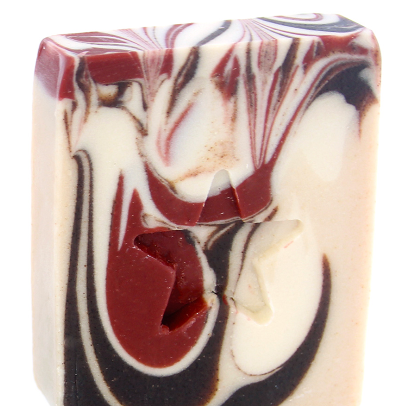 A bar of handmade soap with a marbled pattern of dark brown, light brown, and white colors.